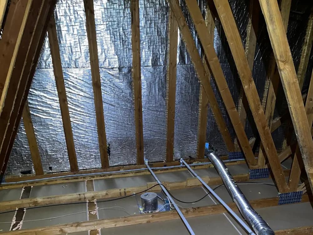 Attic ceiling plane with sealant applied around electrical boxes, pipe penetrations and duct boots.