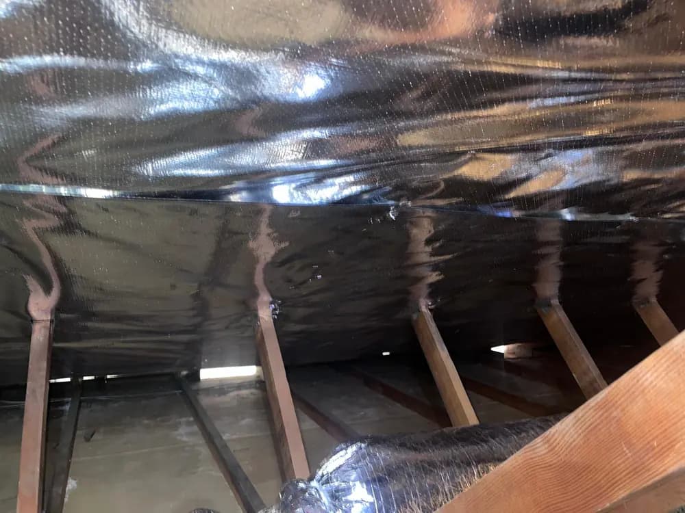 Radiant barrier covering the underside of the roof deck across the full width of the attic.